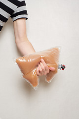 Image showing hand holding plastic bag with tap full of apple juice