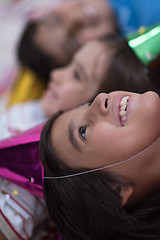 Image showing kids  blowing confetti while lying on the floor