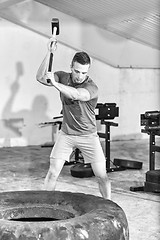 Image showing man workout with hammer and tractor tire