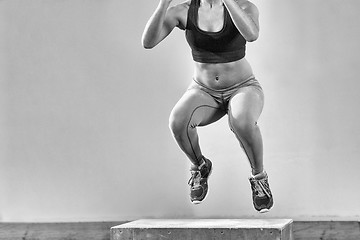 Image showing black woman is performing box jumps at gym