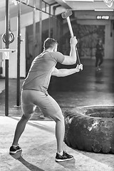 Image showing man workout with hammer and tractor tire