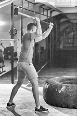 Image showing man workout with hammer and tractor tire