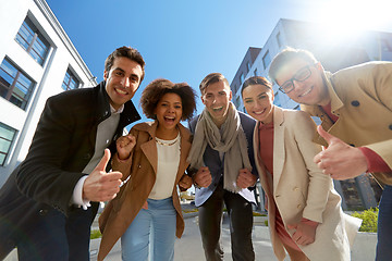 Image showing group of people showing thumbs up in city