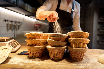 Image showing baker with baskets for dough rising at bakery