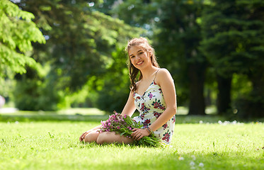 Image showing happy young woman with flowers in summer park