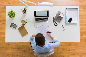 Image showing businesswoman signing contract document at office