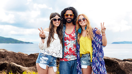 Image showing happy hippie friends showing peace on summer beach