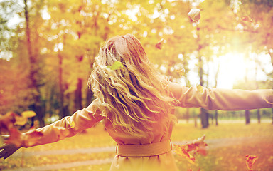 Image showing happy woman having fun with leaves in autumn park