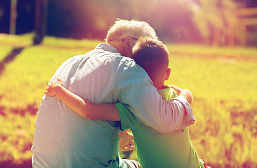 Image showing grandfather and grandson hugging outdoors