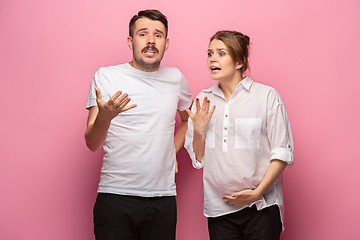 Image showing The funny surprised handsome man and his beautiful pregnant wife\'s tummy