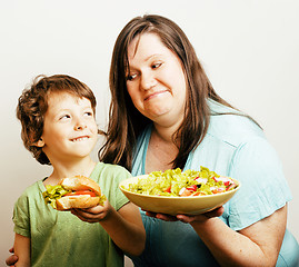 Image showing fat woman holding salad and little cute boy with hamburger teasing