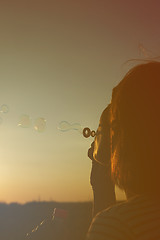 Image showing Girl inflates soap bubbles.