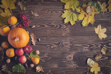 Image showing Ripe yellow pumpkins over wooden background