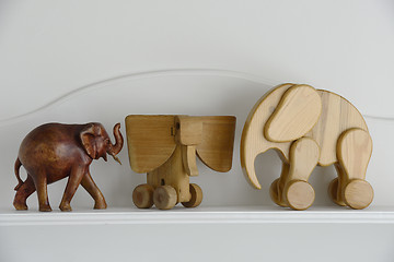 Image showing three wooden elephant sculptures on a neutral background