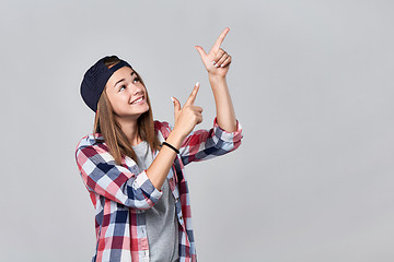 Image showing Teen girl pointing up at empty copy space