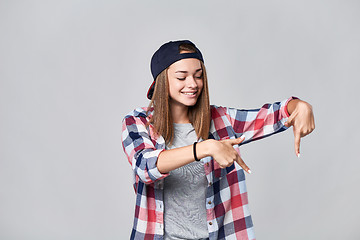 Image showing Teen girl pointing down at empty copy space