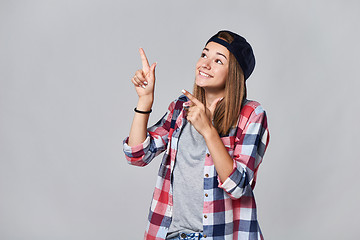 Image showing Teen girl pointing up at empty copy space