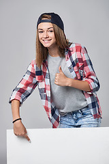 Image showing Teen girl pointing up at empty copy space