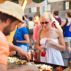 Image showing Woman buying meal at street food festival.