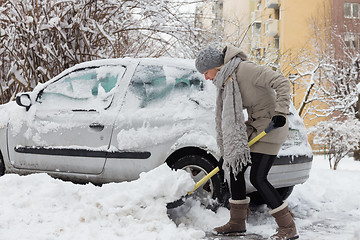 Image showing Independent woman shoveling snow in winter.