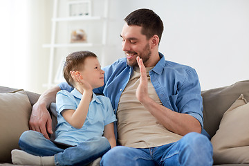 Image showing father and son doing high five at home