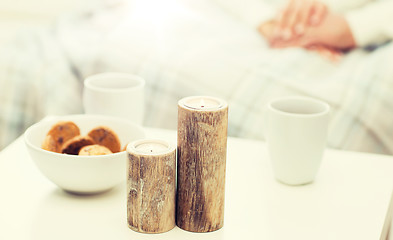 Image showing close up of candles, cookies and tea cups on table