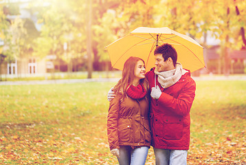 Image showing smiling couple with umbrella in autumn park