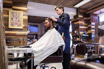 Image showing man and barber styling hair at barbershop