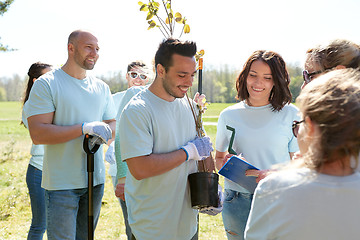Image showing group of volunteers with tree seedlings in park