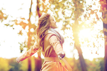 Image showing beautiful happy young woman walking in autumn park