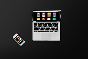 Image showing laptop computer with menu icons and smartphone