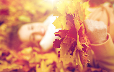 Image showing close up of happy woman lying on autumn leaves