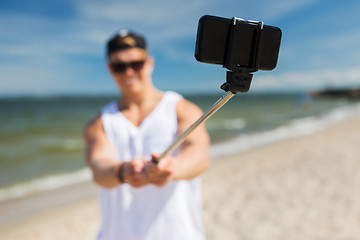 Image showing man with smartphone taking selfie on summer beach