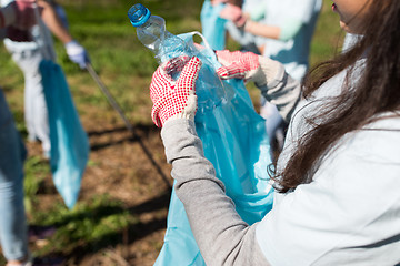 Image showing volunteer with trash bag and bottle cleaning area