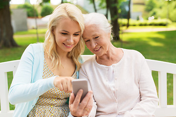 Image showing daughter and senior mother with smartphone at park