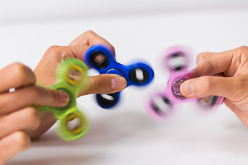 Image showing close up of hands playing with fidget spinners