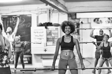 Image showing black woman lifting empty bar