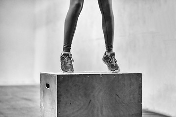 Image showing black woman is performing box jumps at gym