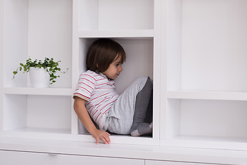 Image showing young boy posing on a shelf