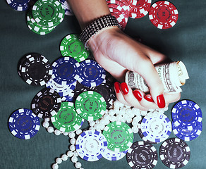 Image showing hands of young caucasian woman with red manicure at casino table close up