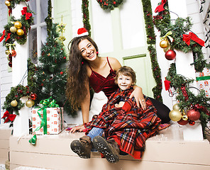 Image showing happy family on Christmas in red hats waiting gests and smiling