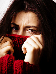 Image showing young brunette gloomy woman in sweater all over her face, messed hair