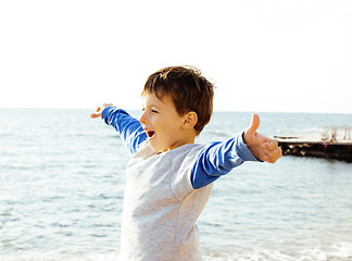 Image showing little cute boy on sea coast thumbs up