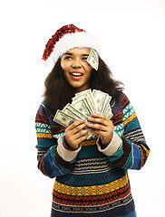 Image showing cute young girl in santas red hat with money isolated