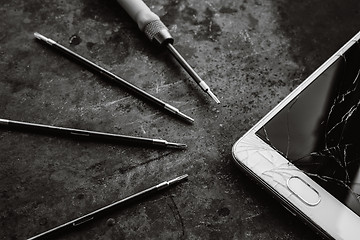 Image showing Smartphone with a broken screen and repair tools.