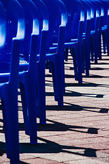 Image showing Bright plastic chairs standing in a row.