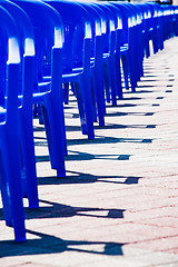 Image showing Bright plastic chairs standing in a row.