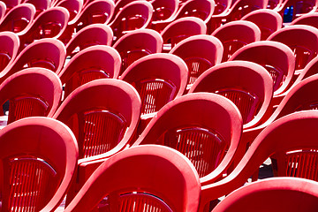 Image showing Bright plastic chairs standing in a row.