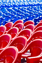 Image showing Bright plastic chairs standing in a row.