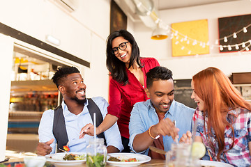 Image showing happy friends eating at restaurant